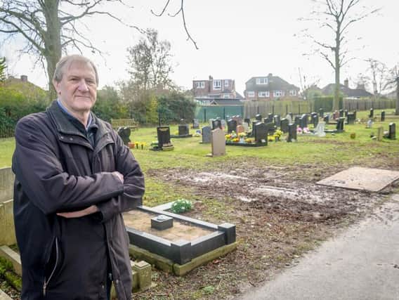 Peter Buckle next to his wife's grave. He is dismayed at how the ground next to it has been churned up.