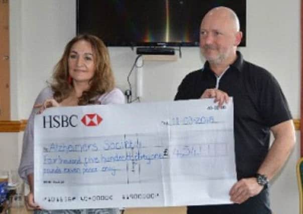 Mike Klodzinski presents a cheque to Lisa Courtney of the Alzheimers Society from his year of captains charity fundraising