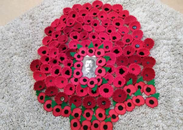 Some of Sandra's handmade poppies around a photo of her grandad.