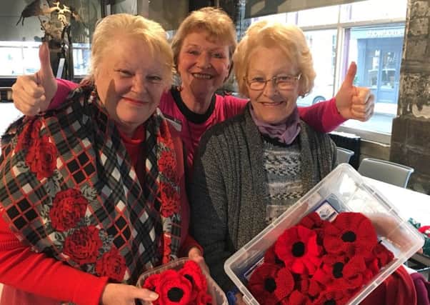 Museum volunteer Kathryn Seren (middle) with two local crafters with poppies they have made over the last few weeks