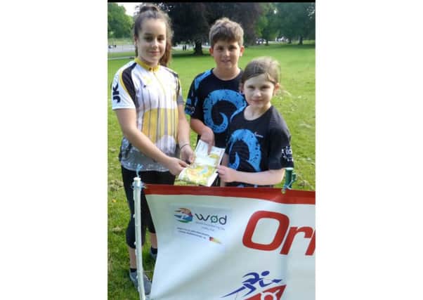 Josie Smart W14 showing Josh Griffin and his sister Laila, Year 3, how to read the map at the World Orienteering Day event