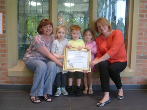 From left: Nursery Manager, Mrs Clare Bird (left) and Early Years Foundation Stage Teacher, Lisa OCarroll-Bailey (right) holding the certificate with some of the nursery children.