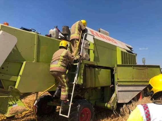 Fire crews with the combine harvester. Photo: Warwickshire Fire and Rescue Service