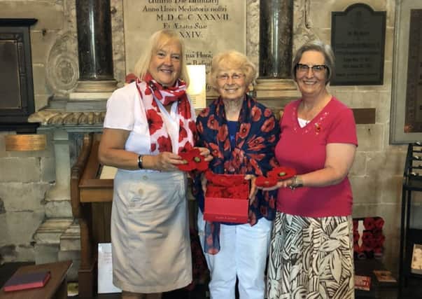 Helen Fitzpatrick from the Warwick Poppies 2018 collecting the handmade poppies from Ricki Webb and her daughter Kelly.