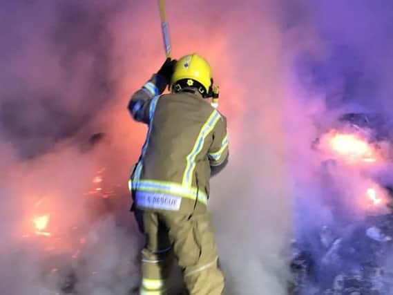 A firefighter tackling the out of control bonfire. Photo: Warwickshire Fire and Rescue Service