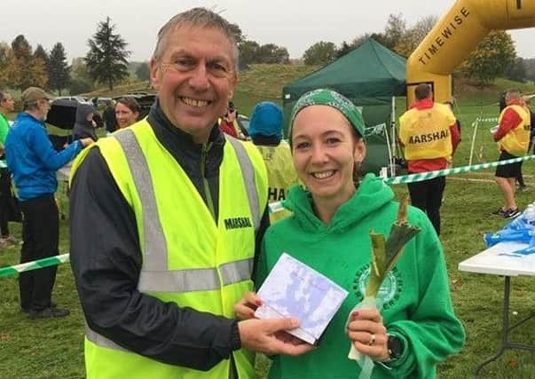 Rachel Miller receives her prize for winning the ladies race at the Green Leek 10k from David Moorcroft.