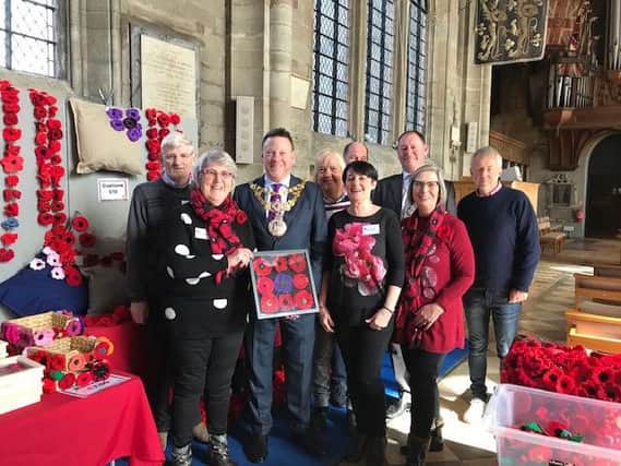 The Warwick Poppies team presenting Warwick Mayor Richard Eddy with a framed display of knitted poppies as a mark of their gratitude for his personal support during his Mayoral year. Photo submitted.