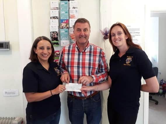 Lion Club members Tamara Friedrich and Hannah Johnson presenting 
the cheque to Safeline CEO Neil Henderson. Photo submitted.