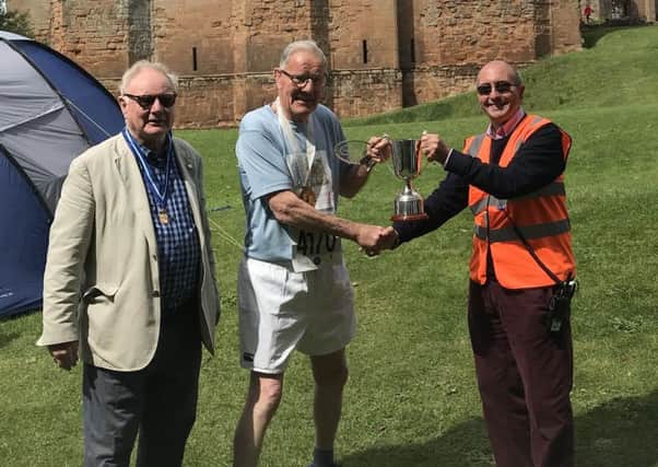 Mike Tansey is presented with a trophy for being the oldest finisher at the Two Castles Run. Pictures submitted