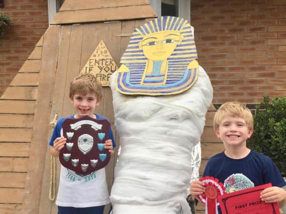 Toby and Ollie Watters stand next to their winning scarecrow - The Last Wonder of the World