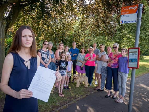 Sarah Holland holding the letter from Warwickshire County Council with other Hatton Park parents and children.
