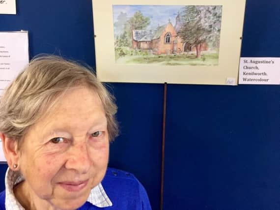 Gillie Carrington stands next to one of her Kenilworth paintings