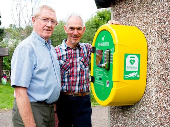 Keith Grierson, with Kenilworth HeartSafe, and Chris Coton, with the Kenilworth Allotment Tenants Association, stand next to the new defibrillator for the Odibourne Allotments