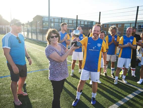 Catherine Smith presents the winning trophy for the Soccer 8s charity football tournament to her son, Carl Smith, who played on the winning team - Real Sociable
(Photo by Ben Duffy)