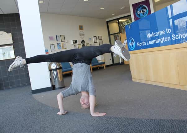 North Leamington sixth form student Rachel Edwards performing a headstand as part of her charity challenge for the Teenage Cancer Trust.