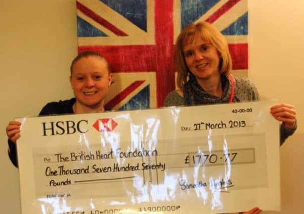 Samantha Hughes presents a cheque to Donna Stubbs of the British Heart Foundation from money raised in memory of Adam Hughes who died of heart failure in October .
