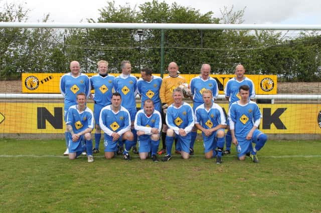 Brakes chairman Jim Scott, back row second from right, lines up with the winning blue team.