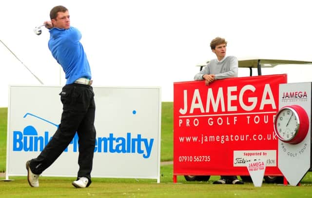 Louie Pett looks on as Rory Kirwan drives off at the start of his second round at The Warwickshire.
