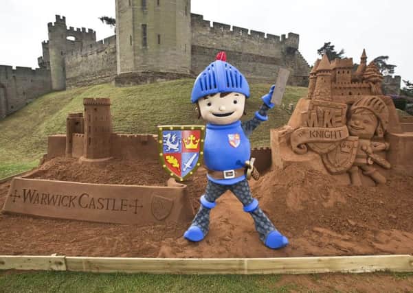 EDITORIAL USE ONLY
A person dressed as CBeebies character Mike the Knight looks on as sand sculptor Raymond Wirick puts the finishing touches to three ten-ton sandcastles of Warwick Castle, Mike the Knights Glendragon Castle and Buckingham Palace, at Warwick Castle in Warwickshire. PRESS ASSOCIATION Picture date: Thursday June 20, 2013. The sand sculptures are being built to coincide with the Summer Solstice, which falls on 21 June, and will hopefully bring a sense of the seaside to Warwick, one of Britains furthermost points from the beach. Visitors to the castle will be able to take part in Mike the Knight activities over the weekends of 29 - 30 June and 6 - 7 July. Photo credit should read: Fabio De Paola/PA Wire