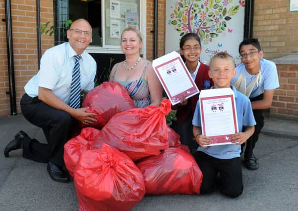MHLC-09-07-13 School donation Jul48 
Whitnash Primary School,has collected bags of donations for Myton Hospice,Miss Jackie Hall (school PA)  and pupilS,Taina Sanghera,Arjun Dhaliwal and Braiden Brown are handing them over to, Nigel Adams from ( Myton Hospice fundraiser ) First left.