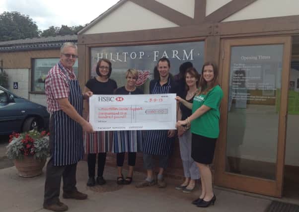Staff at Hilltop Farm present a cheque for £1,100 to Macmillan fundriaisng manager Camilla Wood.