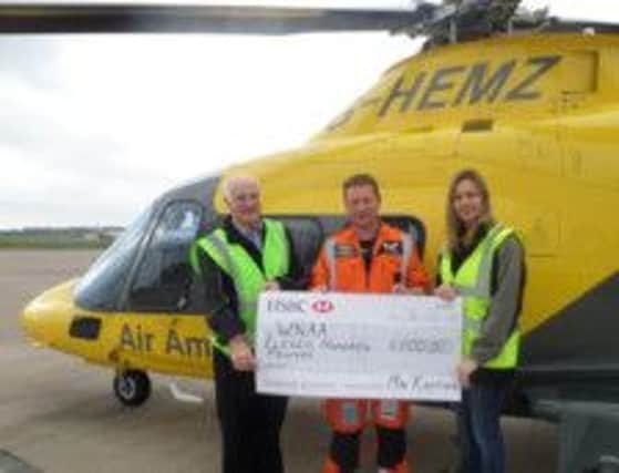 Alan Lettis and Jodi Smith of Mr Karting presenting their donation to Captain Paul Hogan from the Air Ambulance service.