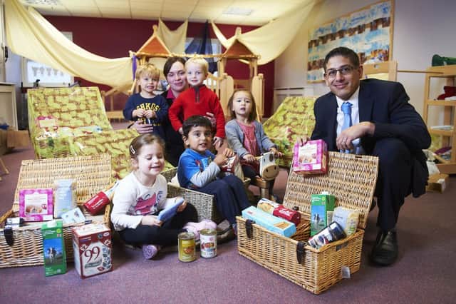 Midcounties Co-operative store manager Mitch Sanghera and deputy manager Nicky Mawby with children at the Co-operative Childcare nursery in Leamington and the donated hampers. Picture by Daniel Greaves.