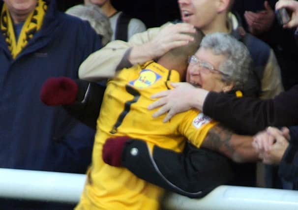 Matt Dodd celebrates with Brakes fan Pauline Fletcher after scoring a second-half  penalty against Guiseley. The midfielder was again successful from the spot against Worcester City in midweek. Picture: Sally Ellis