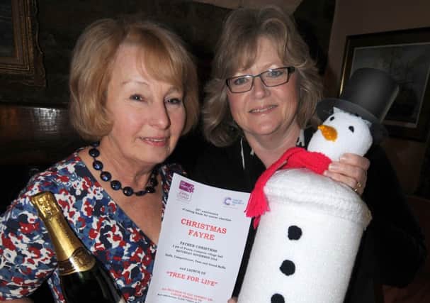 Gay Mathie and Suzanne Pratt show off some of the prizes to be won at their charity Christmas fair.
