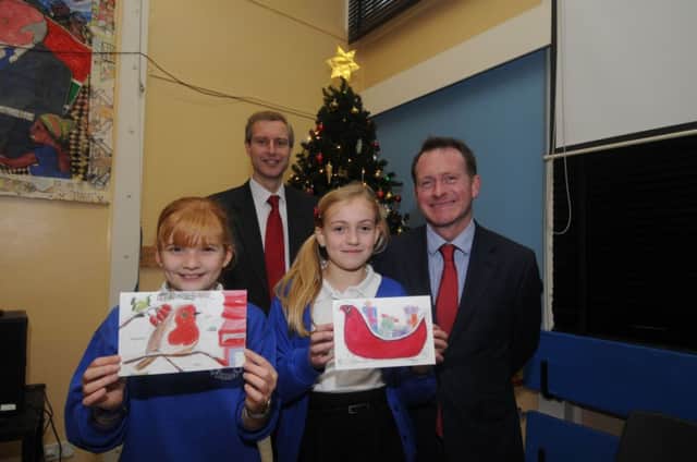 Chris White MP congratulates year 6 Telford Junior School pupils Olivia and Rosie who have won this years competition to design his Christmas card. Also pictured is headteacher Richard Siviter.