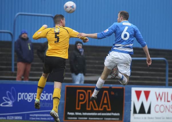 Liam Daly and Barrows Robbie Williams challenge for a high ball at Holker Street. Picture: Milton Haworth