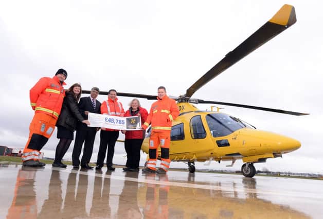 Captain Jonathan Tulley, Andy Williamson (chief executive) and Dr Matt Wyse from the Warwickshire and Northamptonshire Air Ambulance receive their donation from Jo Dyke, community and membership adviser of the Heart of England Co-operative Society and its chief executive Ali Kurji.