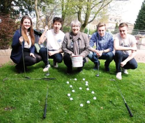 Warwickshire College students Sophie Jones, Joe Coles, Luke Smith and Dan Baker celebrate their donation with Anita Burrows from Myton Hospice.