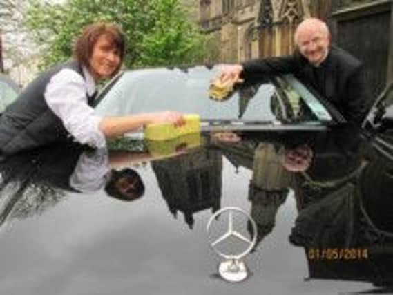 HJ Dawson funeral director Debbie Leah practises cleaning cars with All Saints' church's priest in charge Christopher Wilson ahead of the fundraising car wash.