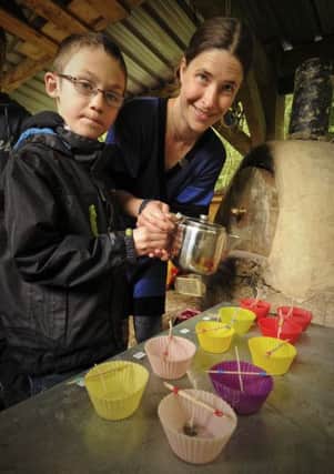 Jill David shows Alex Booth how to make new candles out of old ones at Foundry Wood in Leamington.