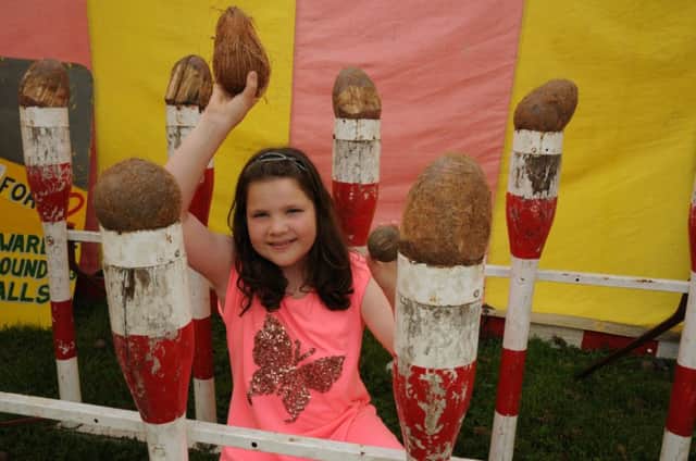 Nine-year-old Amy Strong tries her hand at coconut-shying at the Harbury Carnival.