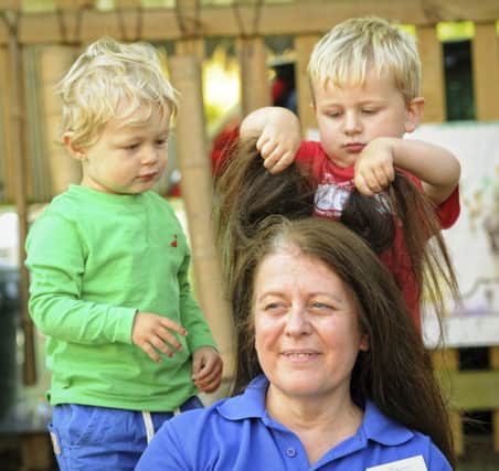 Angie Metcalf, deputy manager at Beehive Nursery, Barford, contemplates her future baldness with children at the nursery.