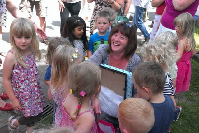 Whitnash Nursery School's headteacher Karen Howell receives a gift from children at her retirement party.