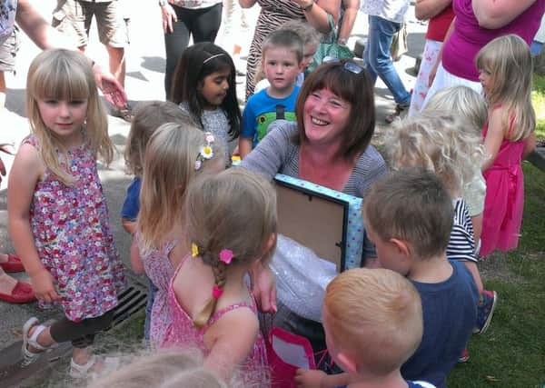 Whitnash Nursery School's headteacher Karen Howell receives a gift from children at her retirement party.