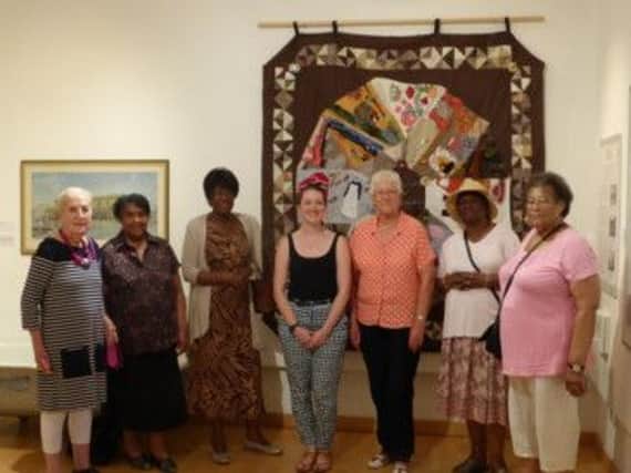 Members of the African Caribbean Project hand over the quilts to Leamington Art Gallery's senior curator Victoria Slade and Cllr Susan Gallagher.