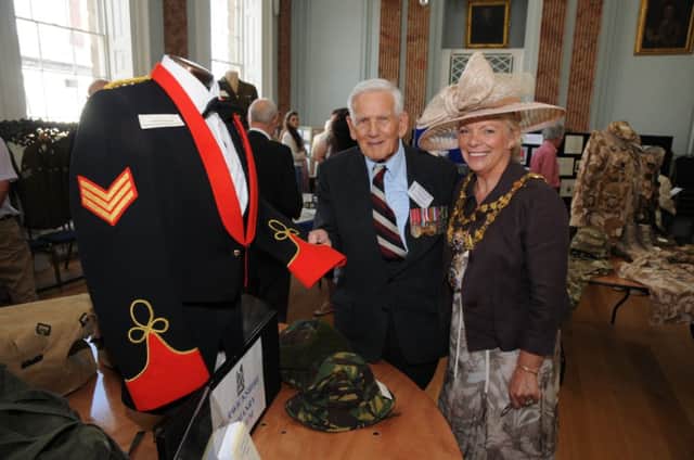 Bryan Johnson of Warwickshire Yeomanry Museum shows Warwick Mayor Cllr Moira-Anne Grainger the uniform he designed.