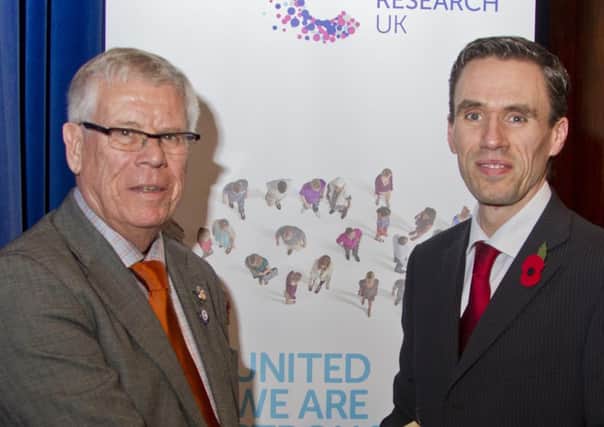 Jeff Reading (left) with Cancer Research regional manager Miles Godfrey, who presented him with his 30 Years Long Service Medal.