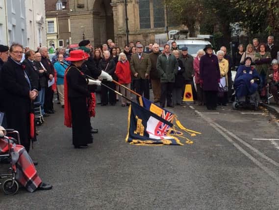 The Armistice Day ceremony in Warwick with cars obstructing part of the road.