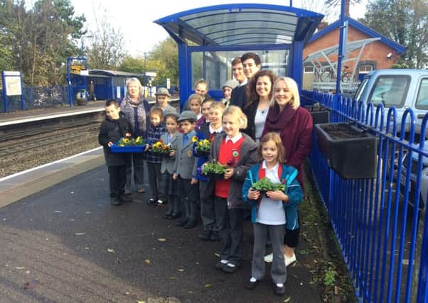 Local schoolchildren help the Friends of Warwick Railway Station by planting winter pansies.