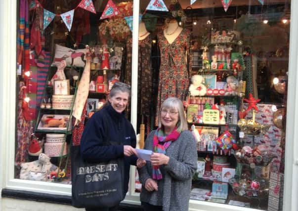 Gill Way (right) receiving cheque for £100 from Sue Butcher, chairwoman of Warwick Chamber of Trade for her winniny entry in Best Shop Window Christmas competition.