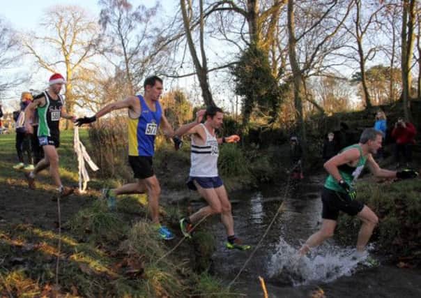 Kenilworth Runners Marc Curtis tackles the stream at Pittville Park in Cheltenham. Picture: Tony Stanton