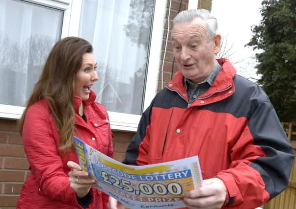 Derrick Ward gets a nice surprise from the Peoples Postcode Lottery ambassador, Judie McCourt - a cheque for £25,000.