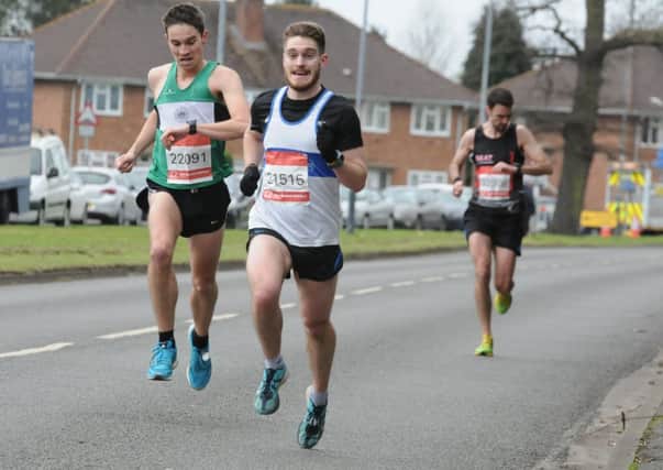 Stephen Page (Kenilworth Runners) comes through to overhaul Leamington C&AC's Jamie Langley. Pictures: Morris Troughton