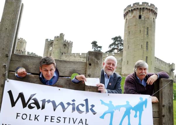 Geoff Spooner, (General Manager, Warwick Castle) offers the £3,500 cheque to John Plumb (Chairman of the Board for Warwick Folk Festival) and Dick Dickson (Festival Director for Warwick Folk Festival) whilst being stuck in the stocks at Warwick Castle 'Warwick Castle Take Stock!'