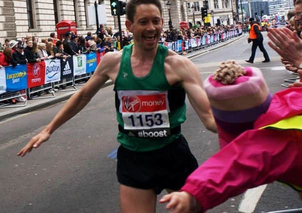 Andrew Siggers takes a high-five from his daughter Sophie in the final stages of the London Marathon on Sunday. Below: Will Eadon